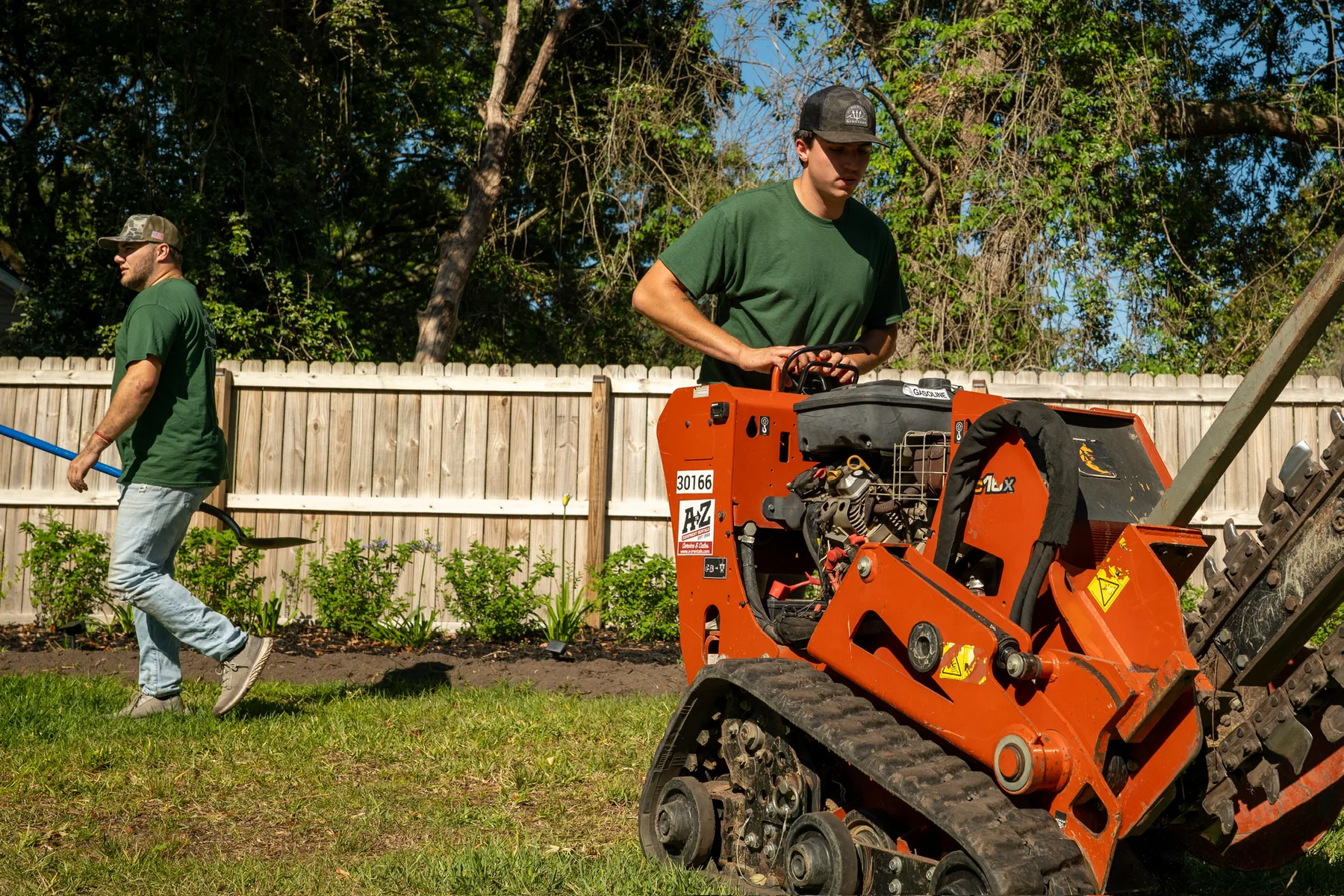 Trenching equipment cutting a clean irrigation line through a lawn